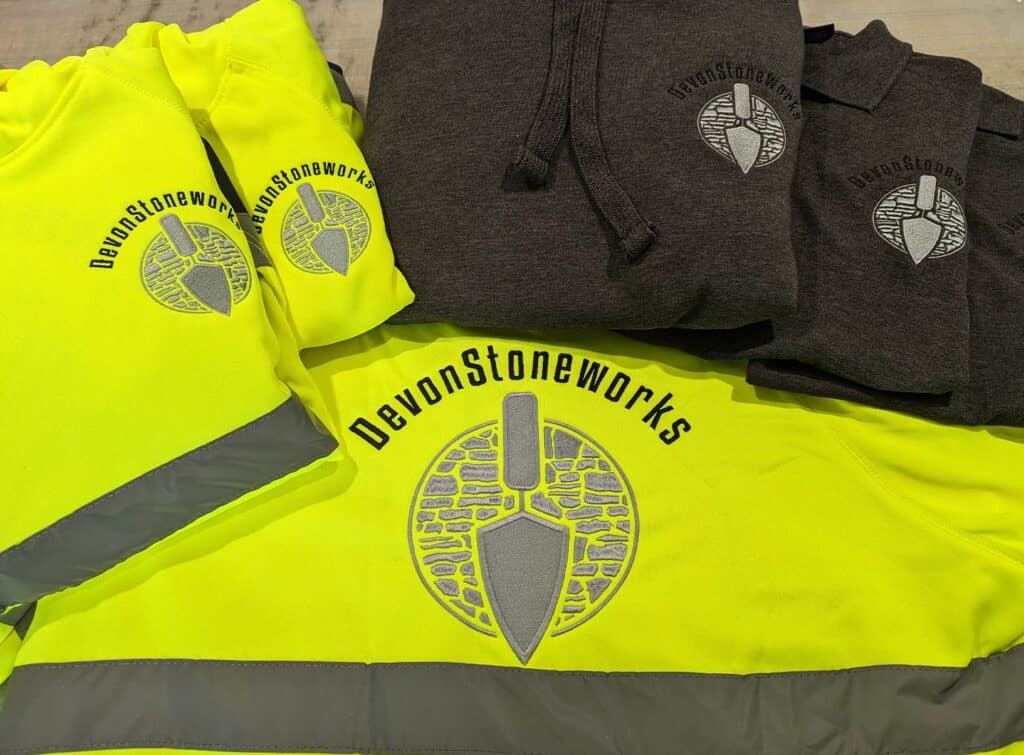 A photograph of the final embroidered clothing products for Devon Stoneworks, produced by Clothing Your Way in Paignton, South Devon.