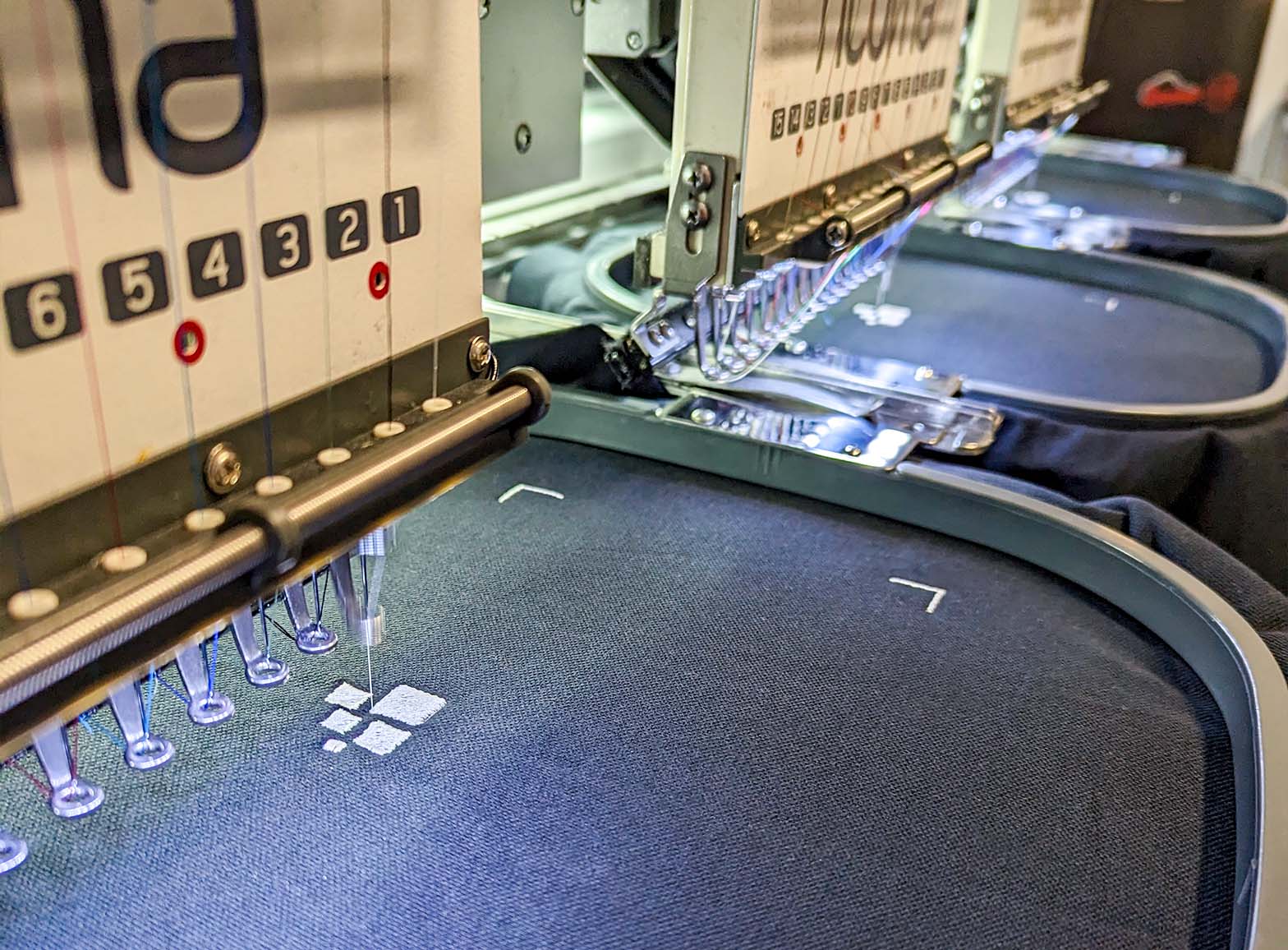 A photograph of the Fine Stitch Embroidery machines working at the Clothing Your Way production studio in Paignton, South Devon.