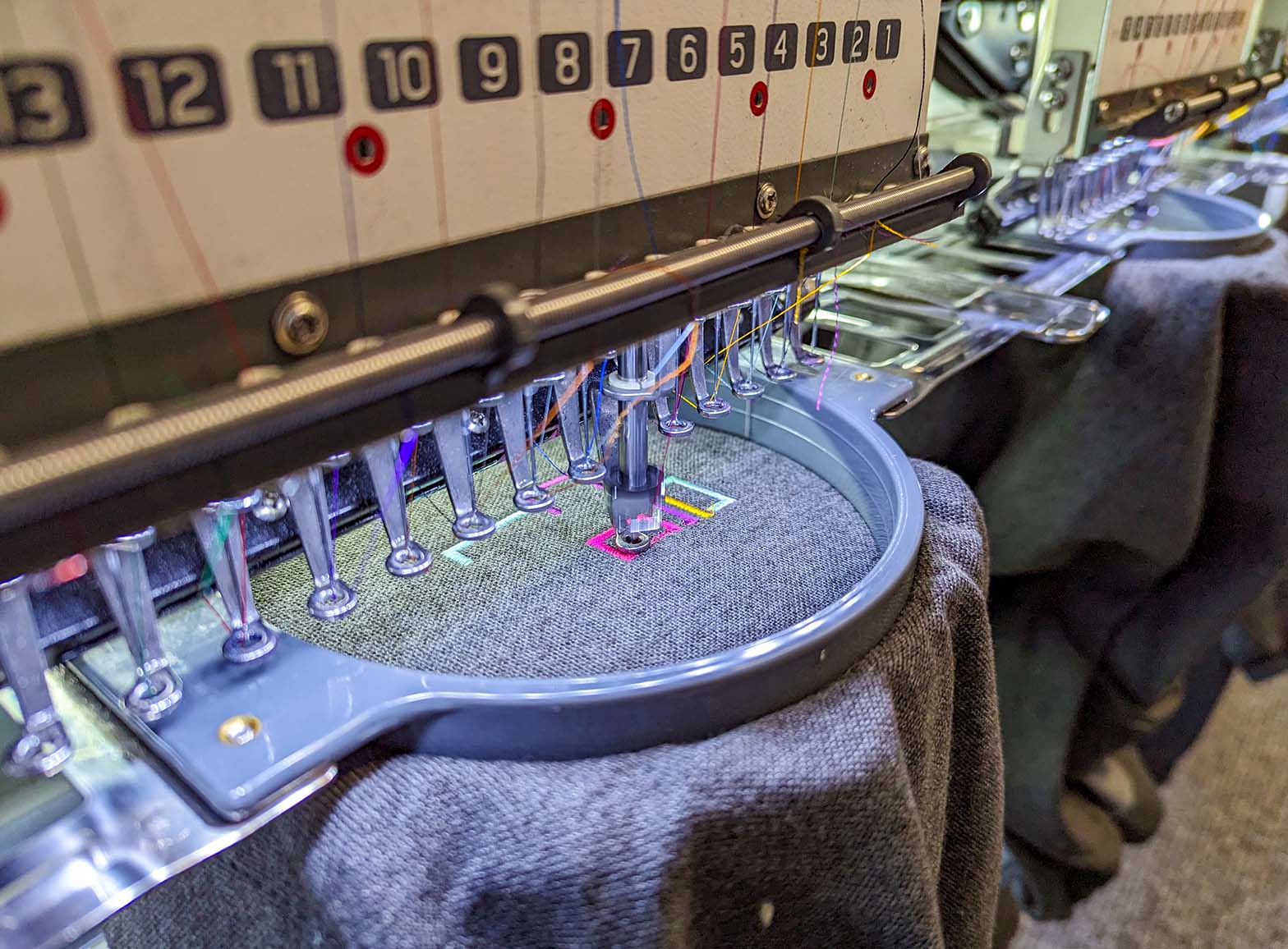 A photograph of the Fine Stitch Embroidery machines working at the Clothing Your Way production studio in Paignton, South Devon.